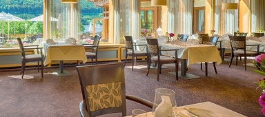 Elegantes Restaurant mit Holztischen und weißer Tischdeko