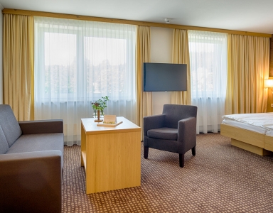 Hotelparkzimmer mit Sitzgelegenheit und großen Fernseher