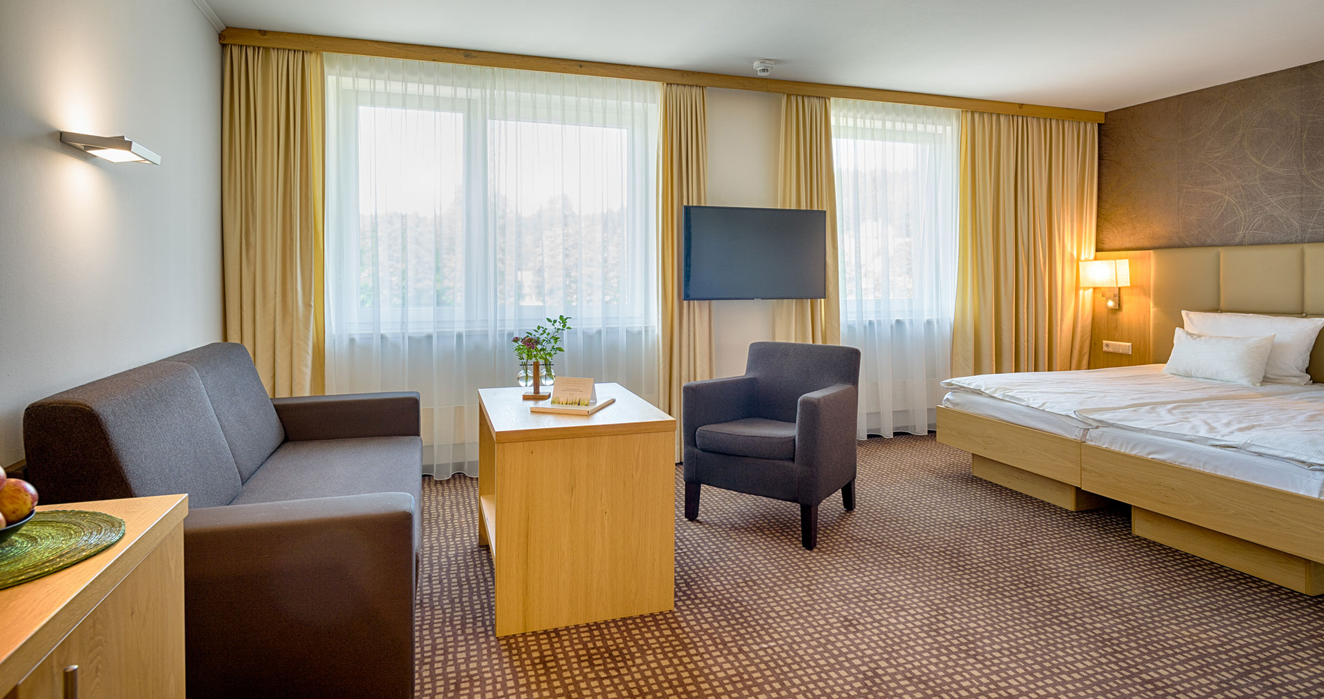 Hotelparkzimmer mit Sitzgelegenheit und großen Fernseher