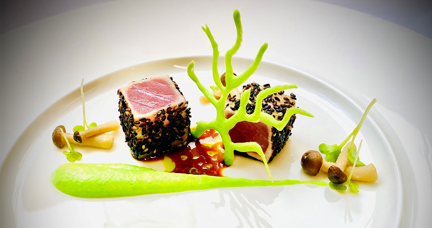 Sesam-Thunfisch, grünes Püree und Pilze auf elegantem weißen Teller.