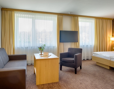 Ein Zimmer mit Sitzecke und großen Doppelbett