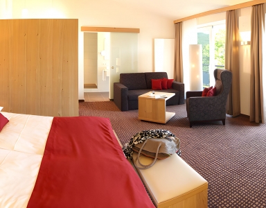 Ein großer Raum mit Doppelbett und Sitzecke