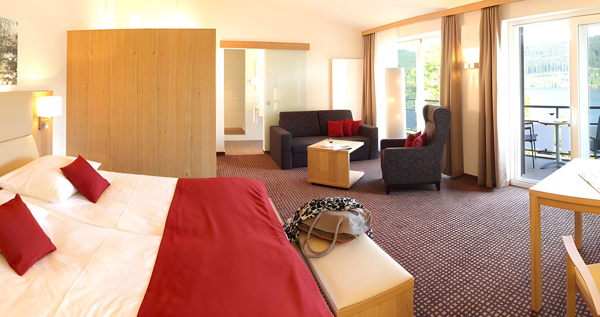 Ein großer Raum mit Doppelbett und Sitzecke