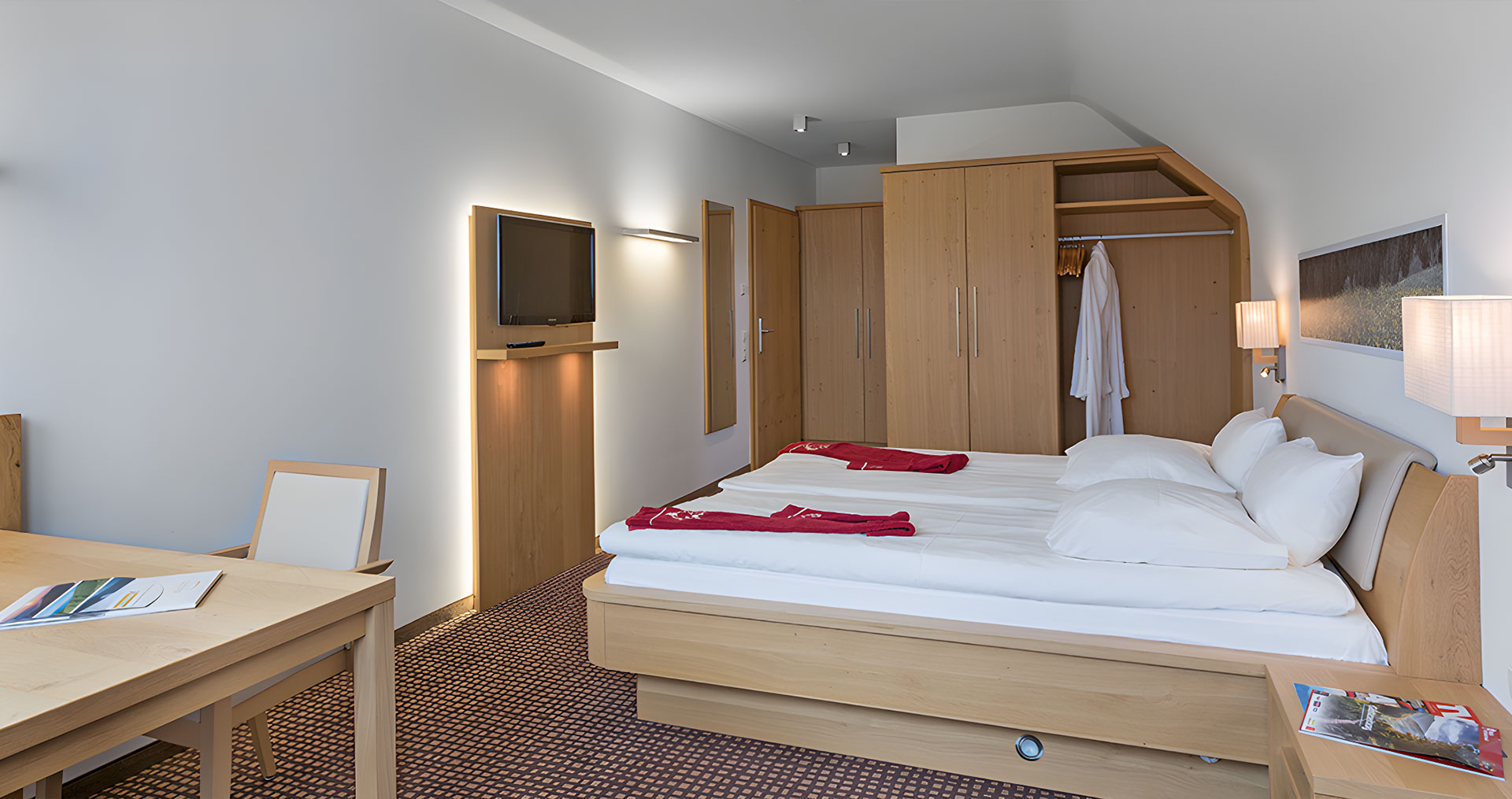 Ein Zimmer mit Doppelbett und Fernseher