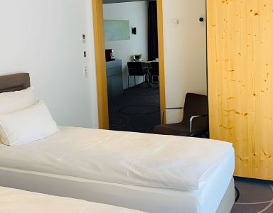 Zwei Einzelbetten und ein heller Schrank im Zimmer.