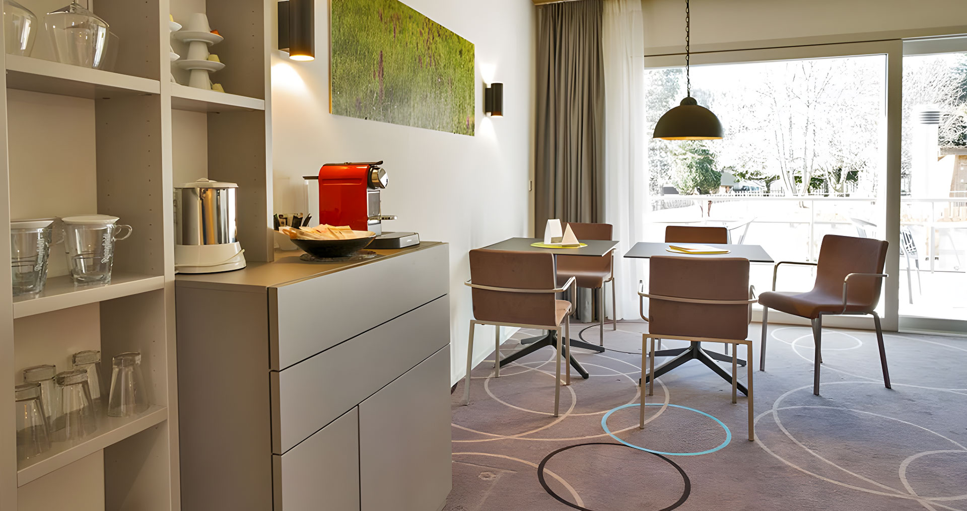 Essbereich mit Kaffeemaschine, Tisch und Stühlen.