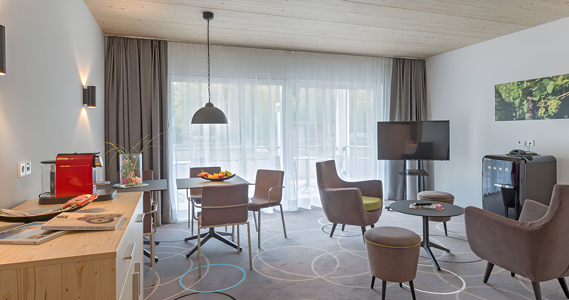 Wohnraum mit Esstisch, TV und bequemen Sesseln.