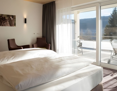 Schlafzimmer mit Doppelbett und Balkonzugang.