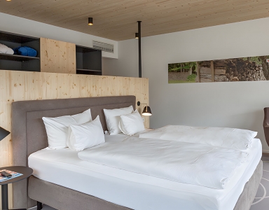 Schlafzimmer mit Holzakzenten und Sitzbereich.